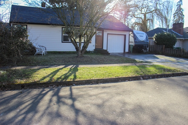 ranch-style home featuring driveway, an attached garage, and fence