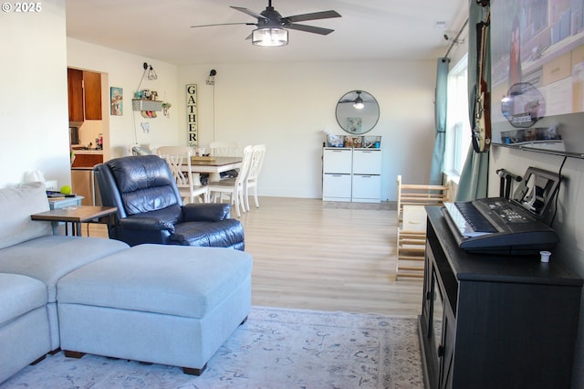 living area featuring light wood-style flooring and a ceiling fan