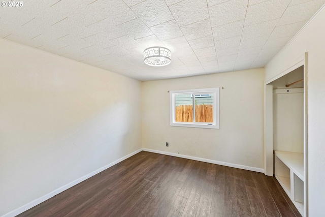 1565 California Ave, Coos Bay, OR 97420 - unfurnished bedroom with dark wood-type flooring and baseboards