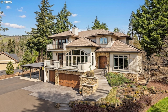 325 Rio Vista Dr, White Salmon, WA 98672 - mediterranean / spanish home featuring stucco siding, stone siding, a balcony, a chimney, and driveway