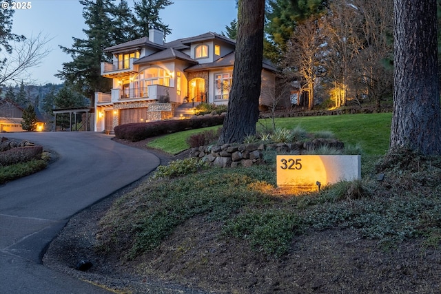 325 Rio Vista Dr, White Salmon, WA 98672 - view of front of property with a balcony, stucco siding, a chimney, an attached garage, and a front yard