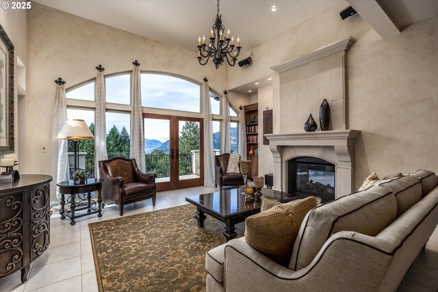 325 Rio Vista Dr, White Salmon, WA 98672 - living area featuring a glass covered fireplace, a notable chandelier, light tile patterned floors, a high ceiling, and built in shelves
