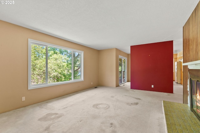 6395 SW Wilson Ave, Beaverton, OR 97008 - unfurnished living room with a fireplace with flush hearth, carpet, and a textured ceiling