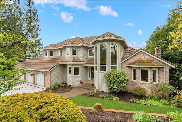 view of front of house featuring a garage, fence, brick siding, a chimney, and driveway