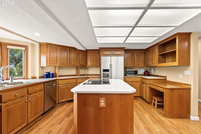 kitchen with open shelves, a kitchen island, brown cabinetry, stainless steel appliances, and a sink
