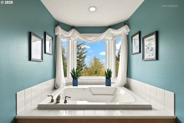 bathroom featuring a textured wall, a jetted tub, and a textured ceiling