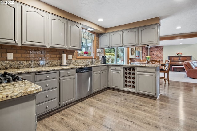 kitchen with tasteful backsplash, gray cabinets, light hardwood / wood-style floors, and dishwasher