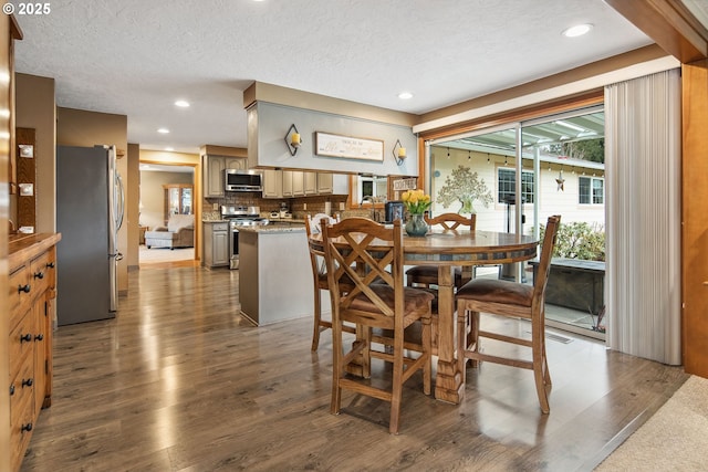 dining room with dark wood-type flooring and a textured ceiling