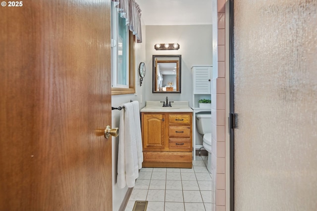 bathroom featuring an enclosed shower, vanity, tile patterned floors, and toilet