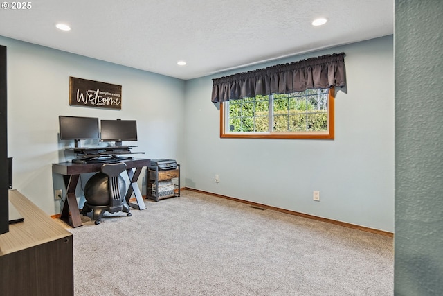 carpeted office with a textured ceiling