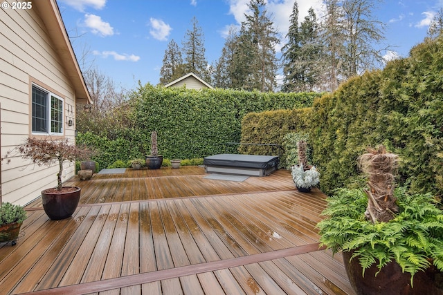 wooden terrace featuring a covered hot tub