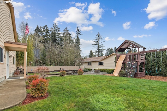 view of yard featuring a playground and a patio