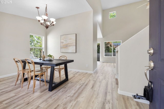 17848 SW Eldred Ln, Sherwood, OR 97140 - dining area featuring a chandelier, light wood-style flooring, baseboards, and a towering ceiling