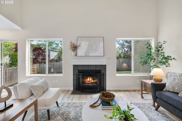 17848 SW Eldred Ln, Sherwood, OR 97140 - living area with wood finished floors, plenty of natural light, a tiled fireplace, and a high ceiling
