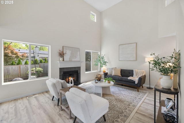 17848 SW Eldred Ln, Sherwood, OR 97140 - living area with high vaulted ceiling, a tiled fireplace, wood finished floors, and baseboards