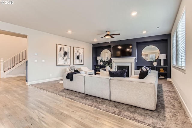 4747 S 17th Dr, Ridgefield, WA 98642 - living room featuring wood finished floors, ceiling fan, a fireplace, and stairs