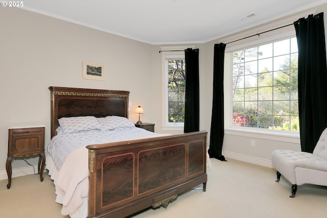 bedroom with baseboards, crown molding, visible vents, and light carpet