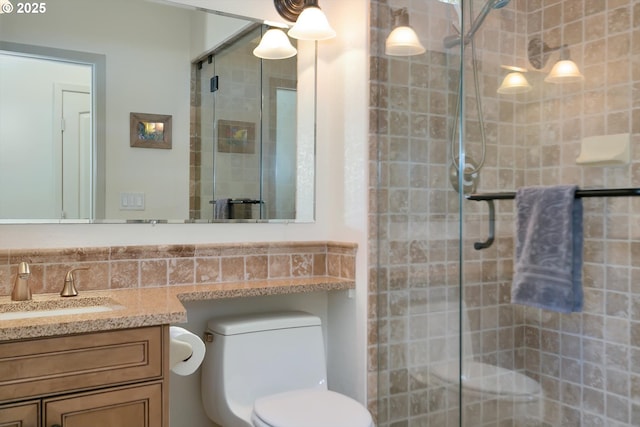 full bathroom with vanity, a shower stall, and toilet