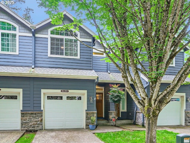 view of front of property featuring stone siding, a garage, and concrete driveway