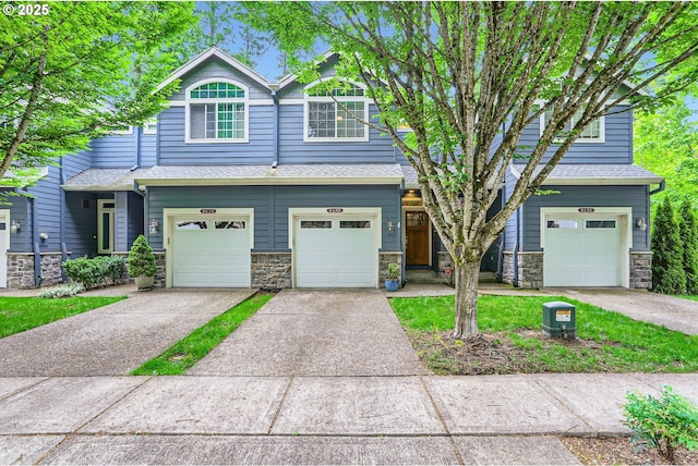 9480 SW 153rd Ave, Beaverton, OR 97007 - view of front of home featuring driveway, an attached garage, stone siding, and roof with shingles