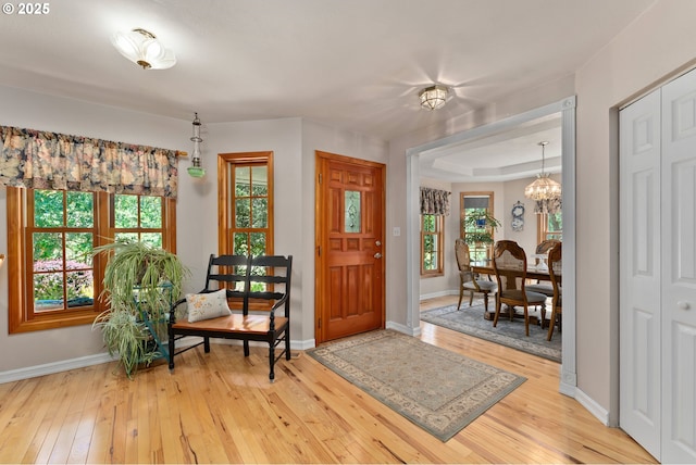 7654 N Bank Rd, Roseburg, OR 97470 - entryway with a chandelier, light wood-style floors, and baseboards