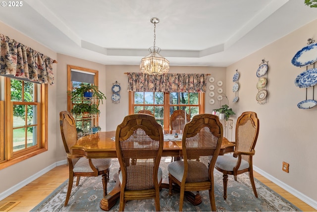 7654 N Bank Rd, Roseburg, OR 97470 - dining space with a chandelier, a raised ceiling, light wood-style flooring, and baseboards