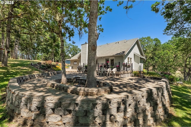 7654 N Bank Rd, Roseburg, OR 97470 - back of house with a deck, a patio area, a chimney, and a lawn