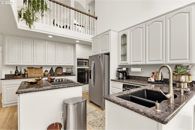 2136 N Thorne St, Newberg, OR 97132 - kitchen featuring black appliances, a sink, dark stone countertops, light wood-style floors, and glass insert cabinets