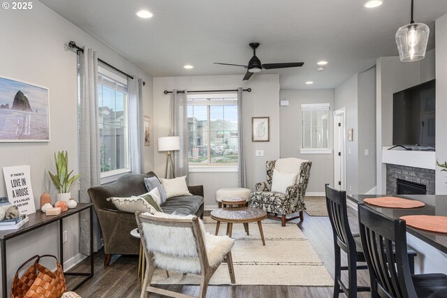 living area featuring wood finished floors, a fireplace, baseboards, recessed lighting, and a ceiling fan
