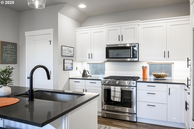 kitchen featuring dark wood-style floors, recessed lighting, white cabinetry, a sink, and appliances with stainless steel finishes