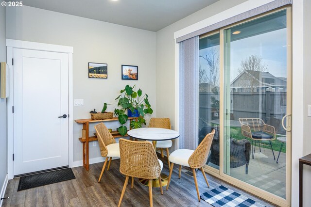 dining area with baseboards and wood finished floors