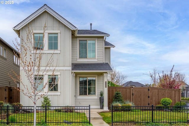view of front of property with board and batten siding, a shingled roof, a fenced front yard, and a front yard