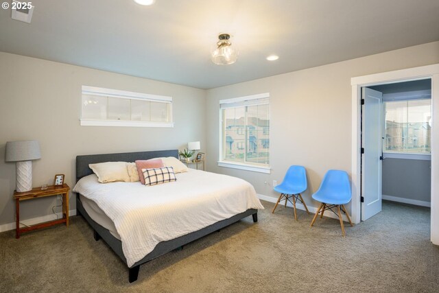 carpeted bedroom featuring recessed lighting, baseboards, and multiple windows