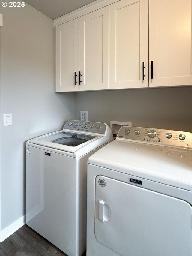 laundry room with dark wood-type flooring, baseboards, cabinet space, and washing machine and dryer