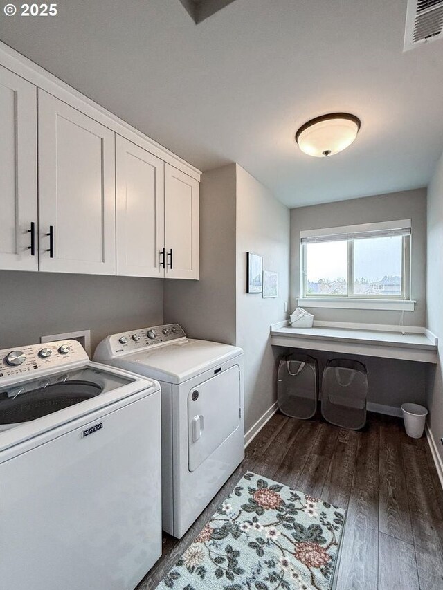 laundry area with visible vents, dark wood-style flooring, baseboards, washing machine and clothes dryer, and cabinet space