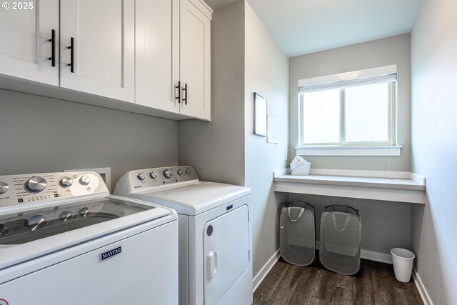laundry room featuring cabinet space, baseboards, washer and clothes dryer, and dark wood-type flooring
