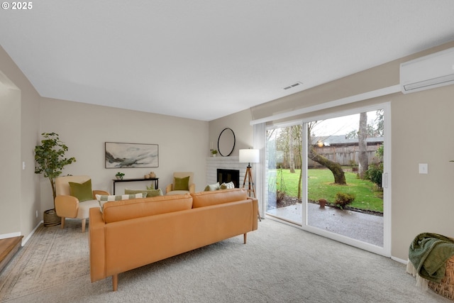 living area with a wall unit AC, a fireplace, visible vents, and baseboards