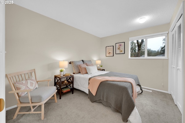 carpeted bedroom with a closet and baseboards