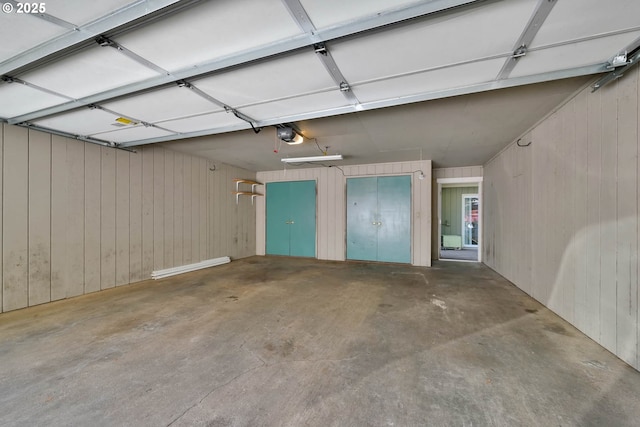 garage with wood walls and a garage door opener