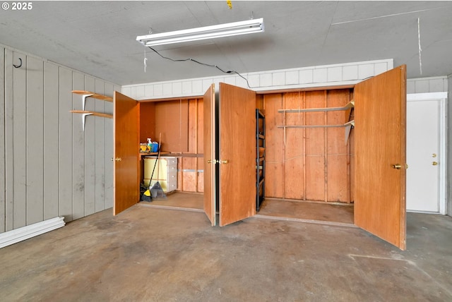 basement featuring wooden walls