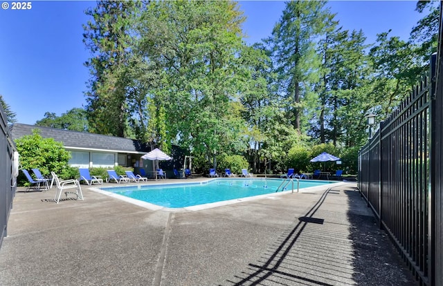 community pool with fence and a patio