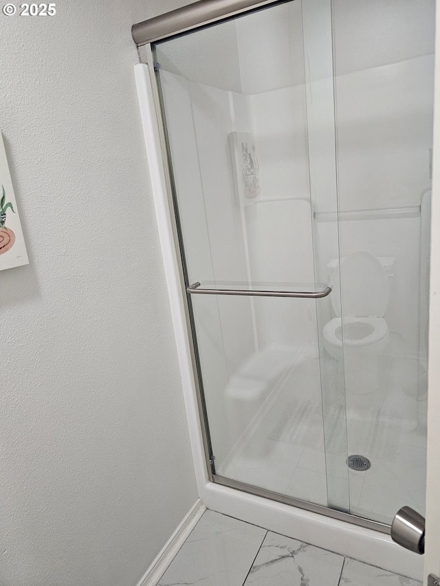 full bath with toilet, baseboards, a shower stall, and marble finish floor