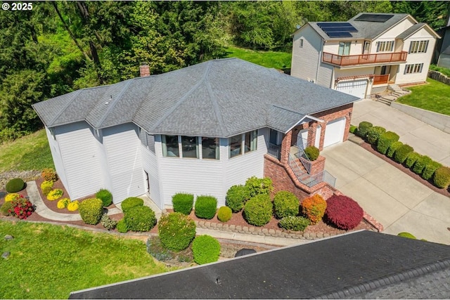 129 Cedar Falls Dr, Kelso, WA 98626 - view of front of property with a balcony, a chimney, driveway, a shingled roof, and solar panels