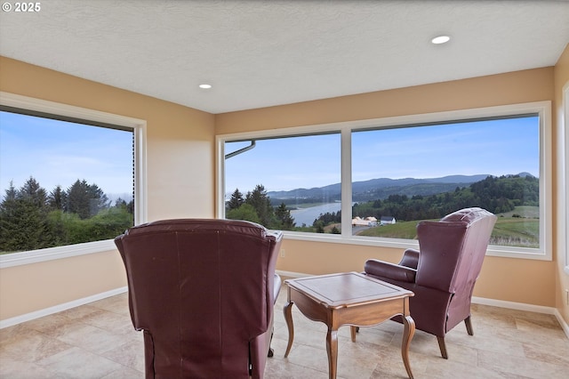 sitting room with a mountain view, baseboards, and recessed lighting