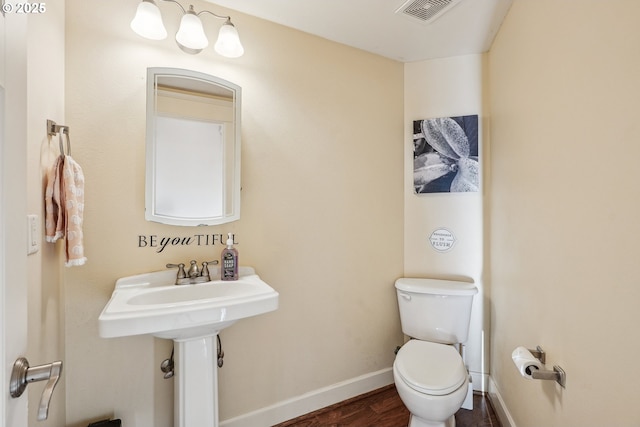 bathroom featuring hardwood / wood-style flooring and toilet