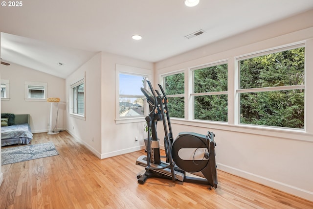 workout room featuring light hardwood / wood-style flooring and vaulted ceiling