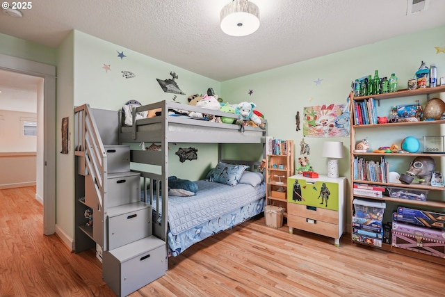 bedroom featuring a textured ceiling and light wood-type flooring