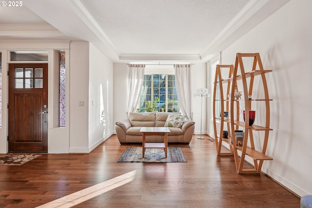 interior space with dark wood-type flooring, ornamental molding, and a textured ceiling