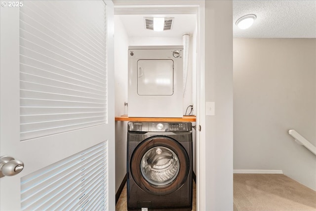 29650 SW Courtside Dr Unit 18, Wilsonville, OR 97070 - laundry area with stacked washer and clothes dryer, carpet, and baseboards
