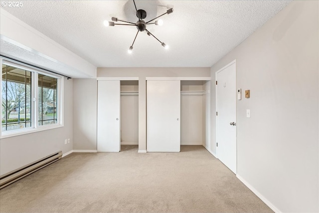 29650 SW Courtside Dr Unit 18, Wilsonville, OR 97070 - unfurnished bedroom with two closets, baseboard heating, a textured ceiling, light colored carpet, and baseboards